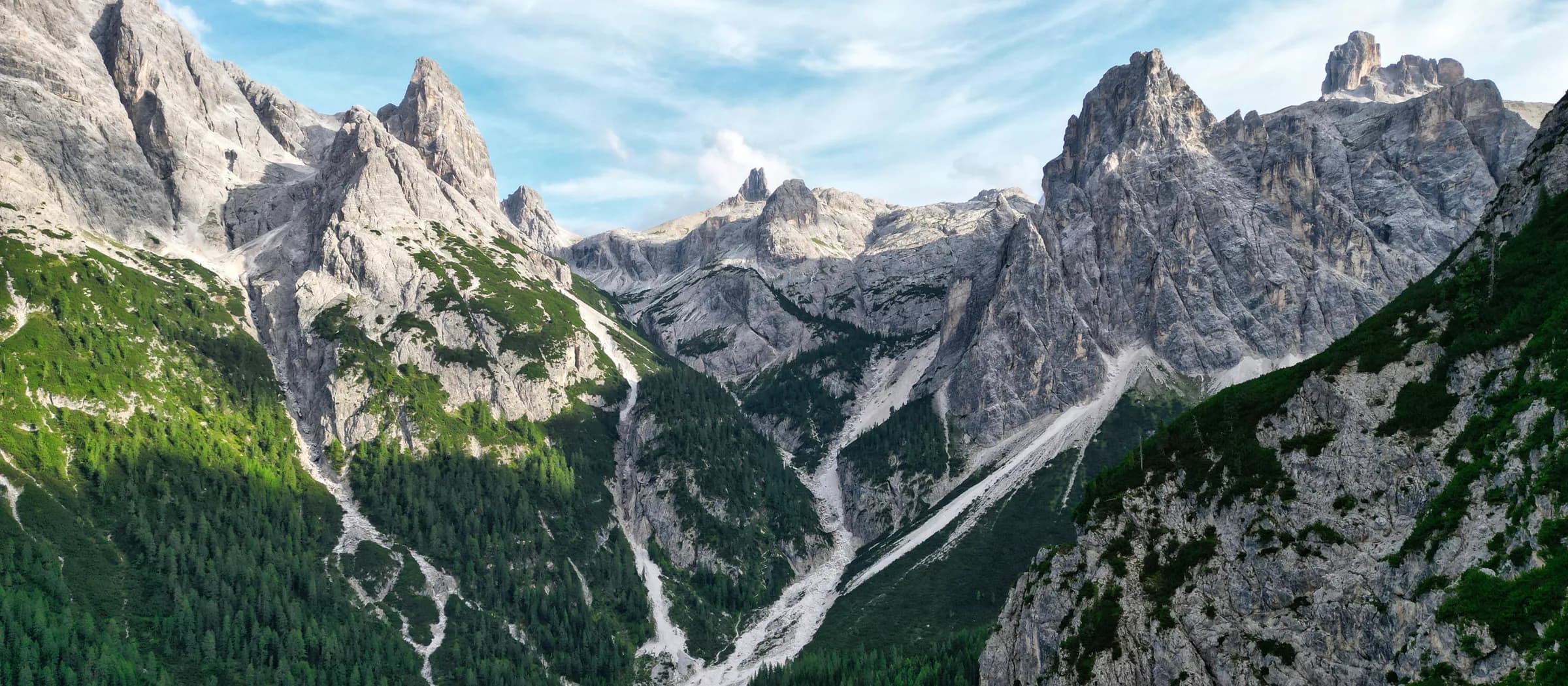 Panoramablick auf Bergkamm und bewaldetes Tal bei sanftem Abendlicht.
